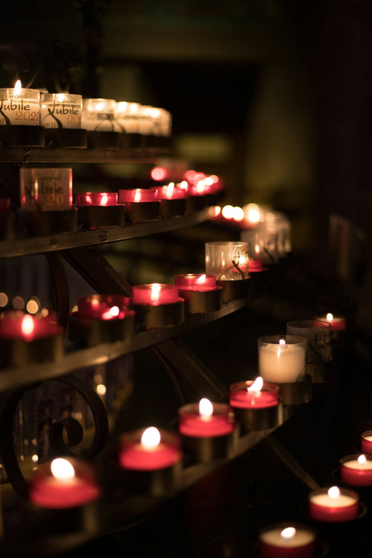 a bunch of lit candles sitting on a shelf