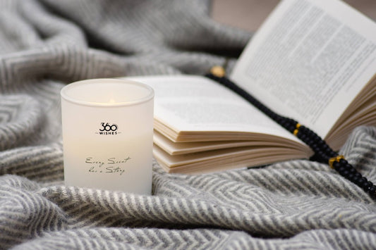 a candle and a book on a blanket